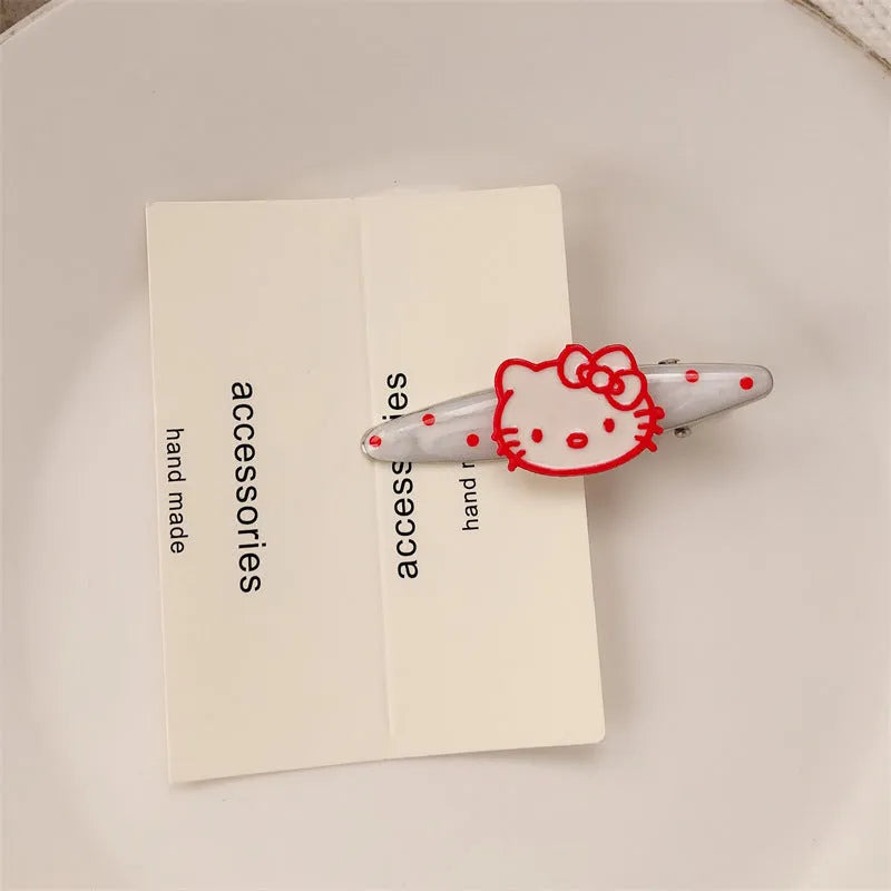 Red plastic hair clip with a 3D love heart and dots on a willow leaf-shaped base.