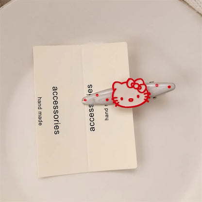 Red plastic hair clip with a 3D love heart and dots on a willow leaf-shaped base.