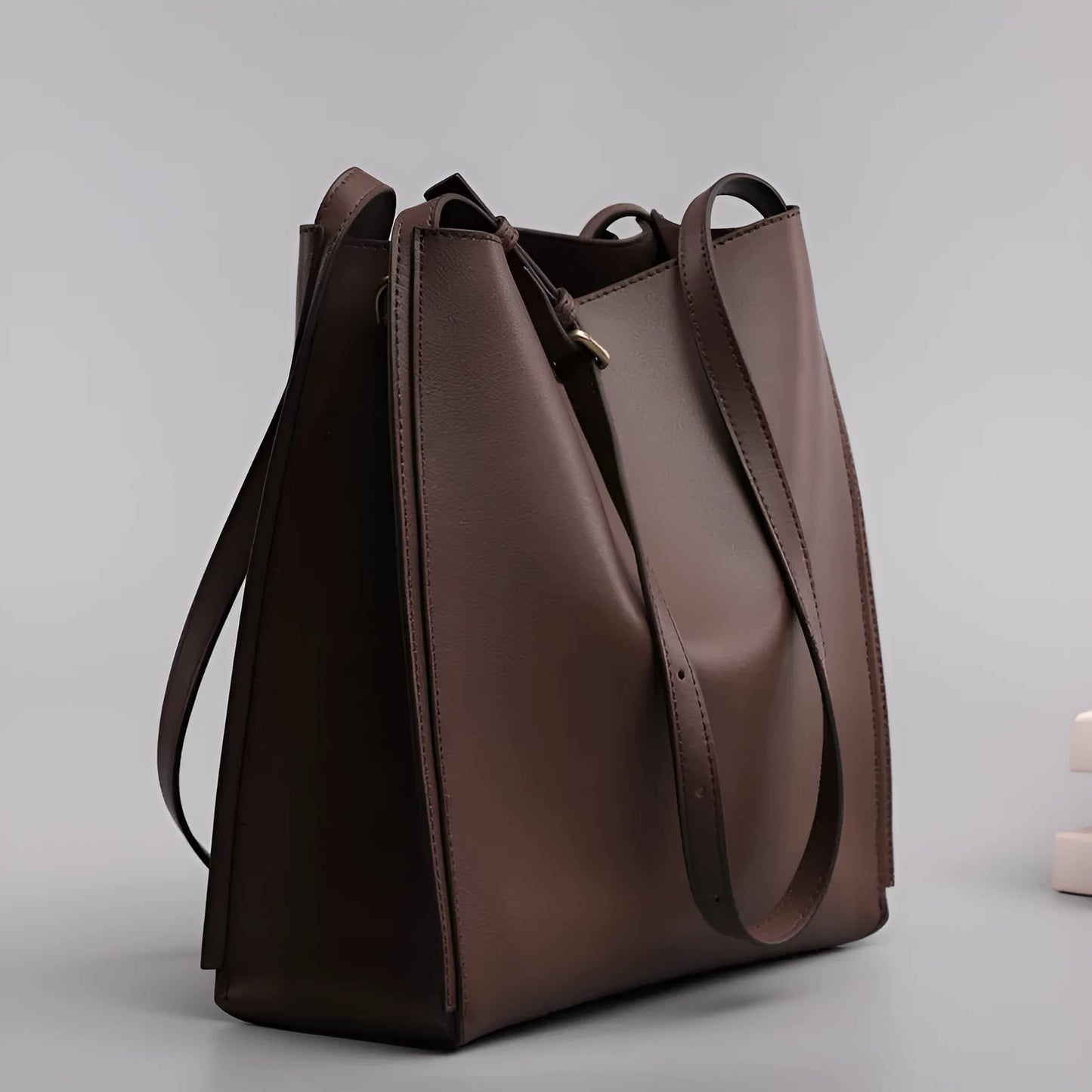 Brown genuine leather women's bucket bag with double shoulder straps showing organisational compartments