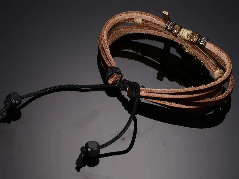 A handcrafted leather bracelet featuring a cross design, perfect for adding a touch of rustic style to any outfit.