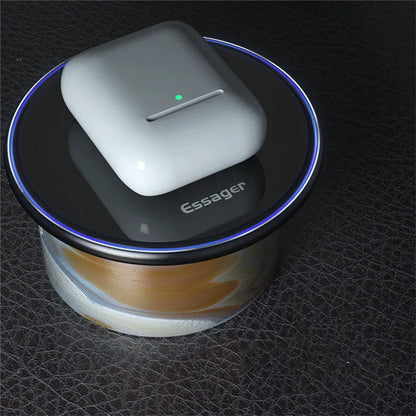Black wireless charger on table with phone charging, showing blue LED light and anti-slip surface