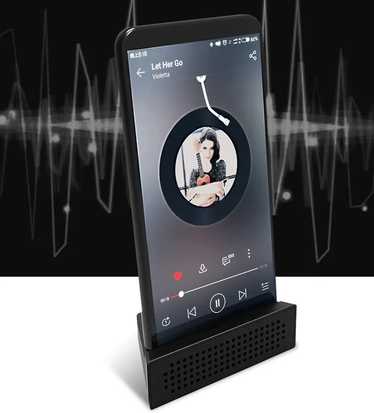 Portable black ABS plastic phone amplifier bracket holding a smartphone on a desk.