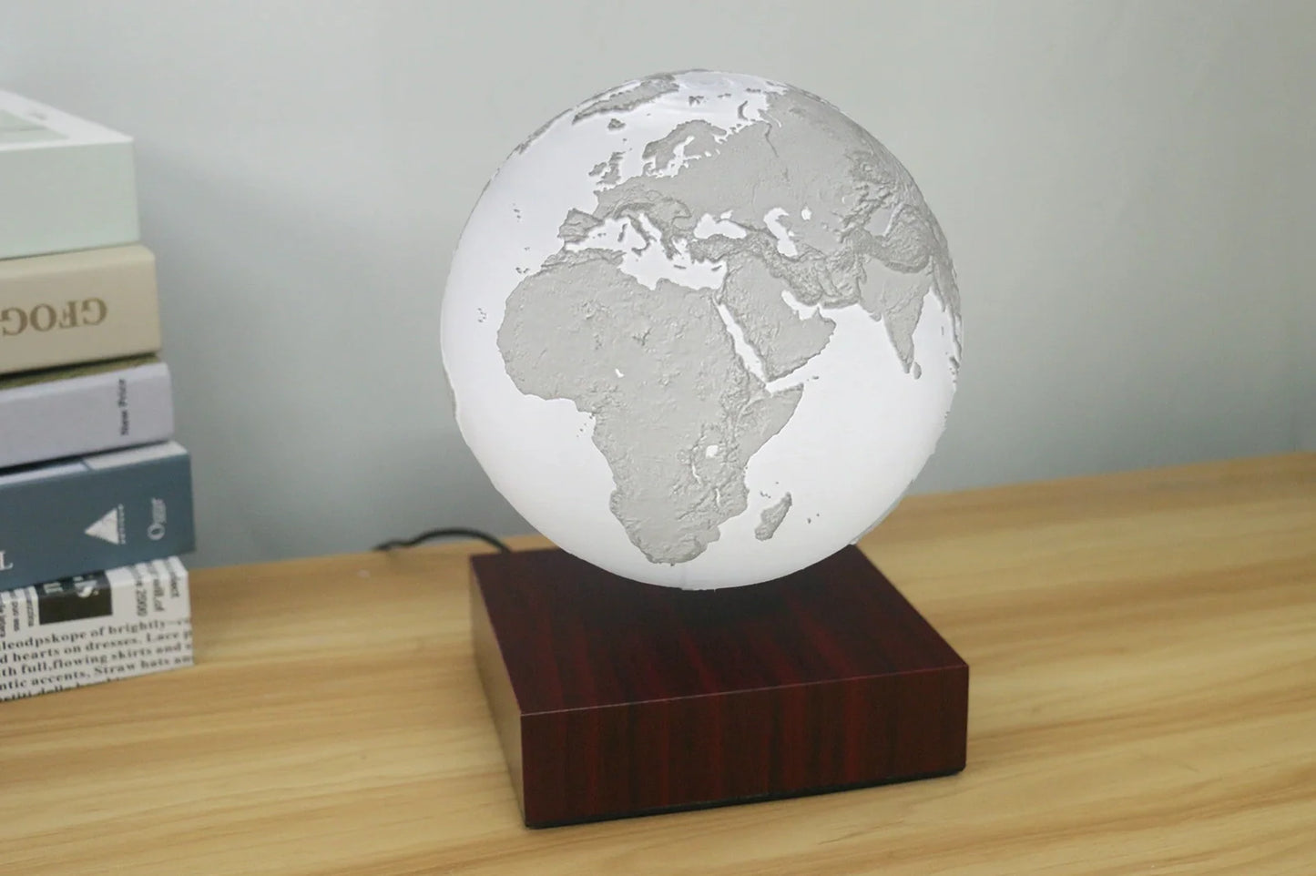 Levitating Earth or Jupiter lamp floating above base with LED illumination