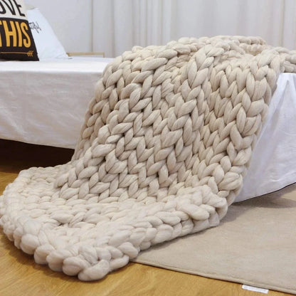 Hand woven wool blanket with soft chenille texture in navy blue colour draped over sofa