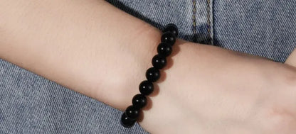 Geometric black agate bracelet for women with 8mm beads on a black elastic cord.