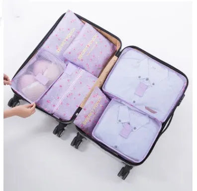 Set of six coloured nylon packing cubes and flat pouches for travel organisation.