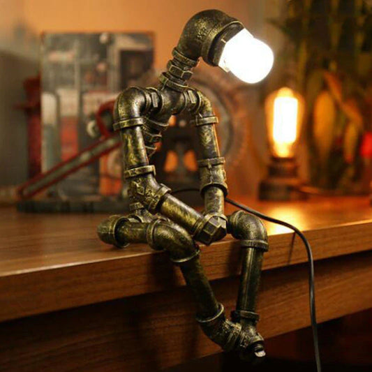 Vintage industrial iron pipe table lamp with soft, warm lighting and a green bronze finish