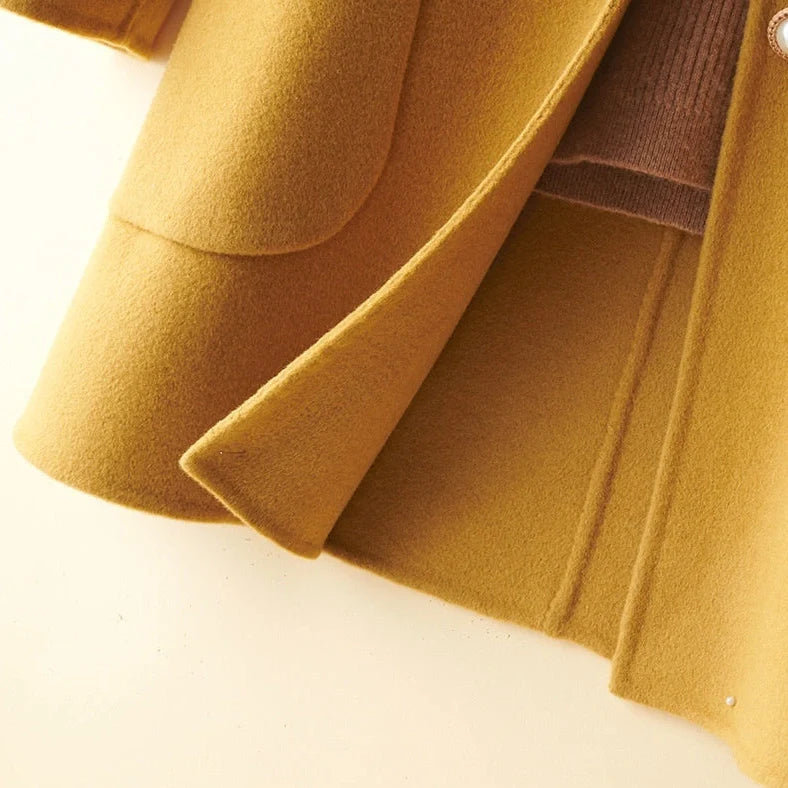 Women's black wool mid-length coat with doll collar and pearl buckle, showing double-faced fabric and 65cm length.