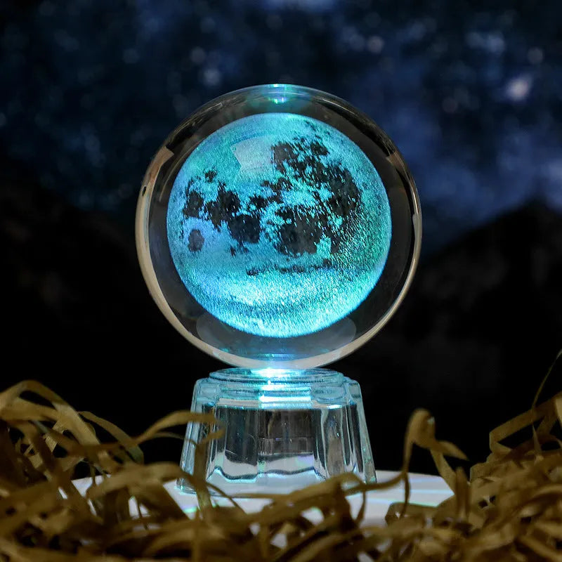 Transparent crystal ball ornament with inner carving of clouds, shown on a wooden table.