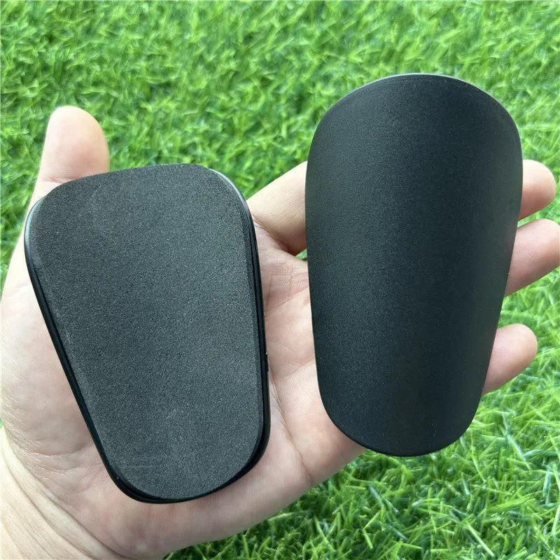 Extra small plastic football shin guards in black and white colours for youth players