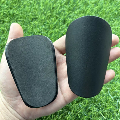 Extra small plastic football shin guards in black and white colours for youth players