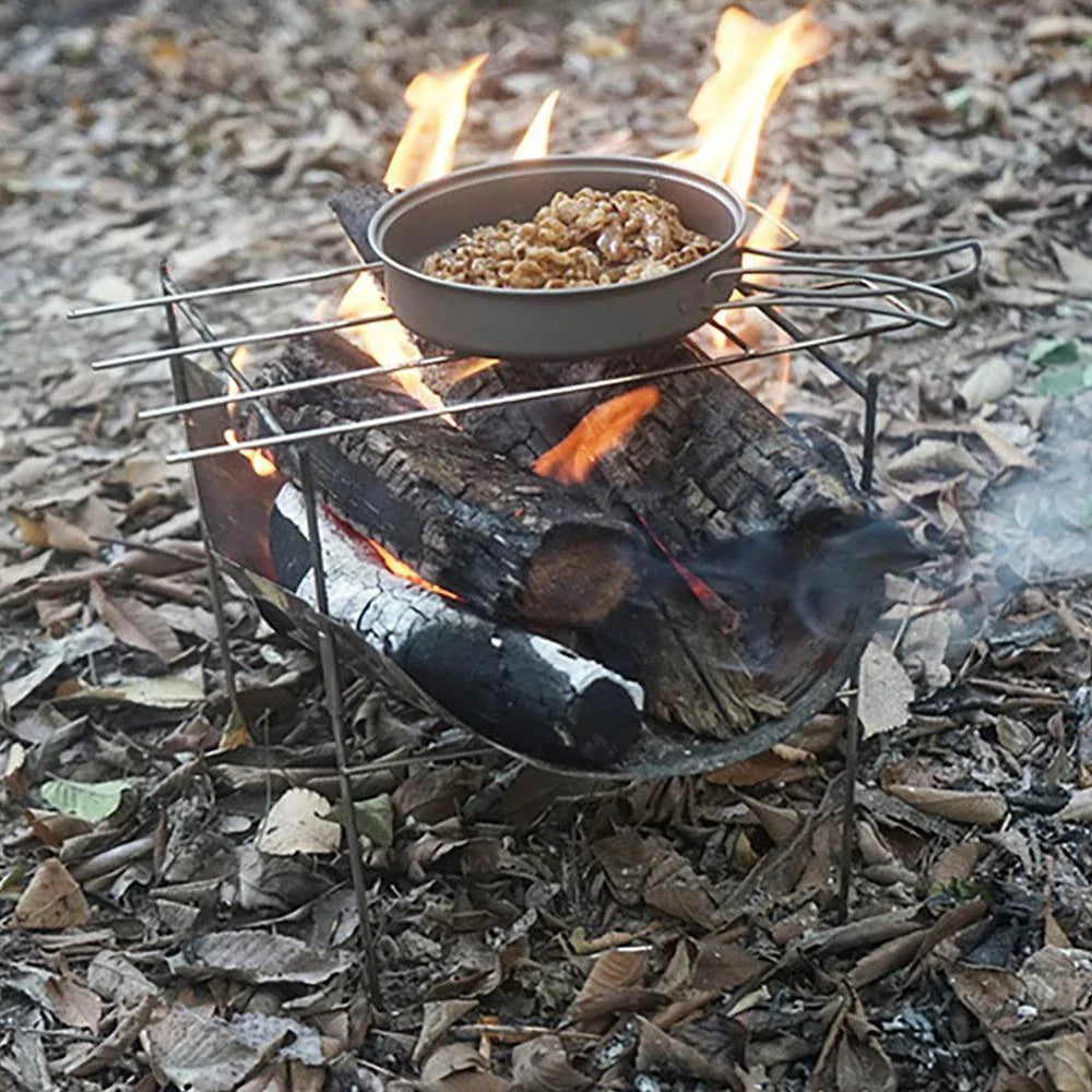 Portable folding outdoor camping stove with grill, made of titanium and stainless steel for durable and versatile outdoor cooking