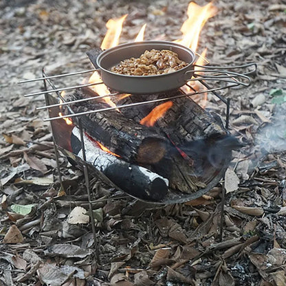 Portable folding outdoor camping stove with grill, made of titanium and stainless steel for durable and versatile outdoor cooking