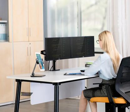 Silver foldable aluminium phone and tablet holder on a wooden desk, showing 360-degree rotation and silicone pads.