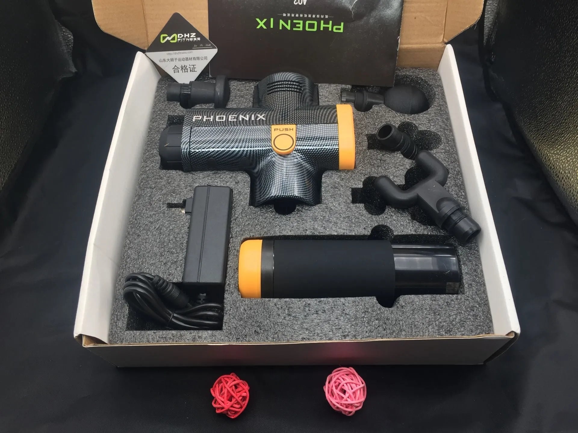 Black fascia massage gun with four interchangeable heads for deep tissue treatment measuring 29x28x28cm