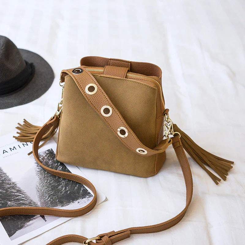 A stylish frosted tassel bucket bag with interior pockets and a versatile shoulder strap design