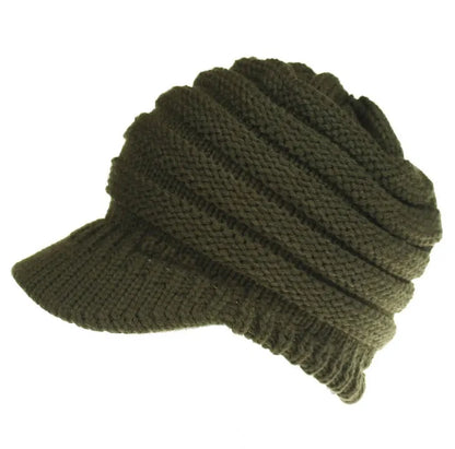 Woman wearing a light grey knitted ponytail beanie with her ponytail pulled through the hole in the back.