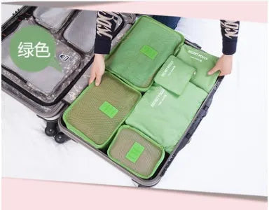 Set of six coloured nylon packing cubes and flat pouches for travel organisation.