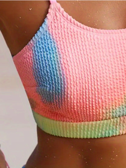 Women's tie-dye pleated split bikini with gradient pattern in polyester fabric showing orange and blue colour options