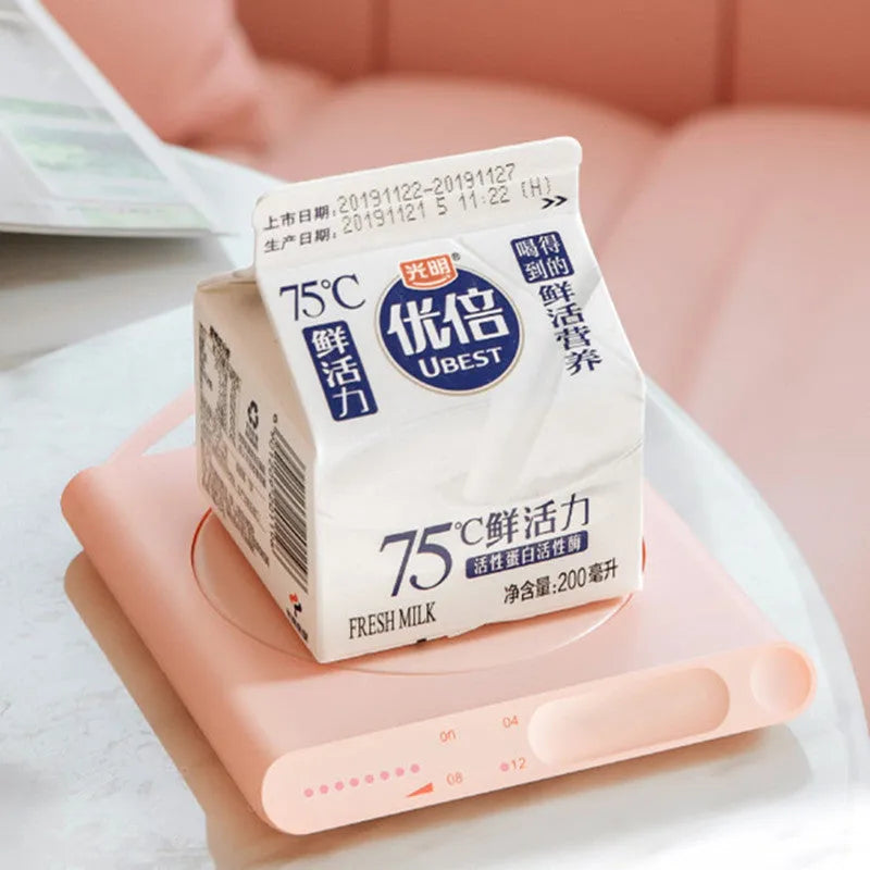 Pink and white USB heating cup pads with mechanical dials on a desk