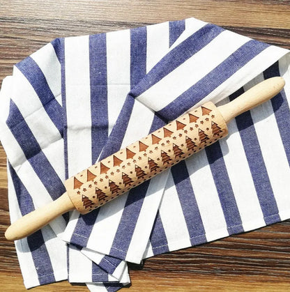Wooden rolling pin with engraved Christmas patterns including reindeer and snowflakes on a 45cm long barrel.