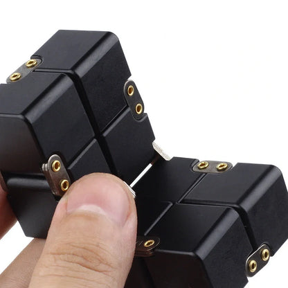 Zinc alloy Infinity Cube with eight rotating cubes showing black and silver colour options on wooden surface