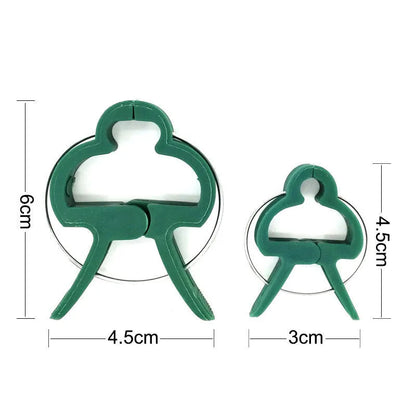 Green plastic plant fixing clips, large and small sizes, holding a tomato stem to a garden cane.
