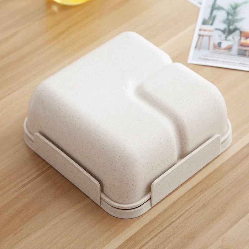 Japanese-style microwave-separated bento box in pink, green, and beige with spoon and chopsticks