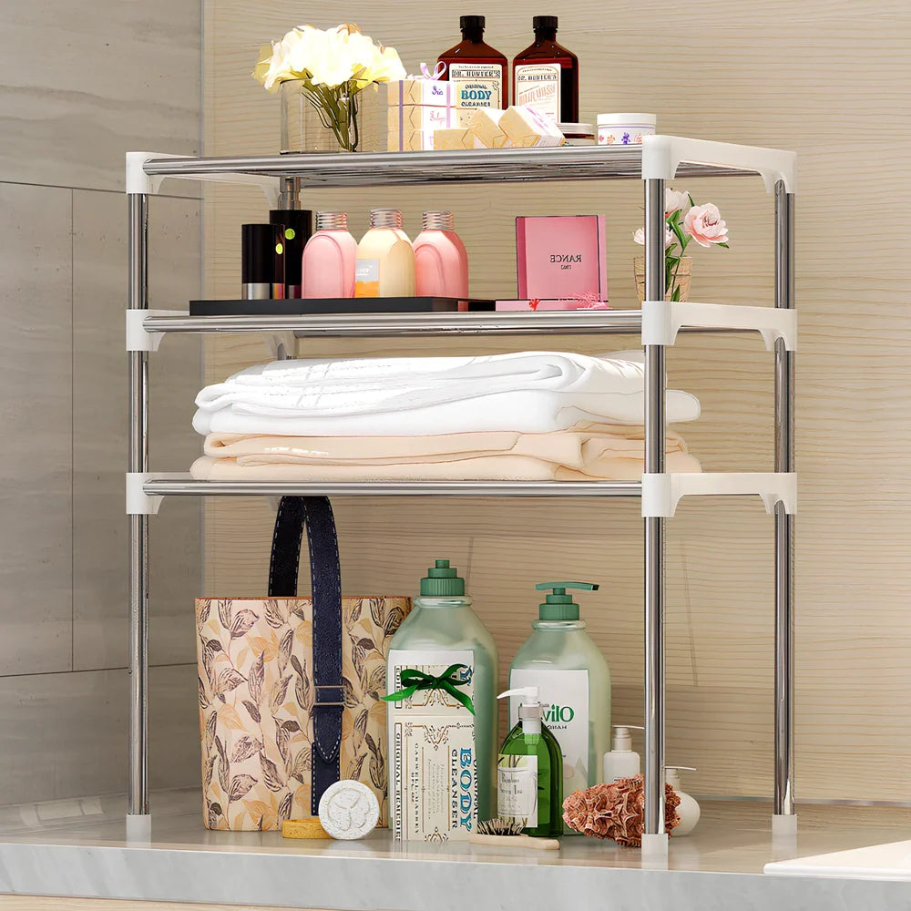 Silver and white microwave shelf rack with iron tubes and plastic connectors measuring 56.9cm wide