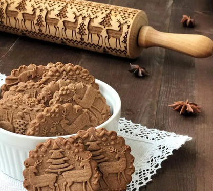 Wooden rolling pin with engraved Christmas patterns including reindeer and snowflakes on a 45cm long barrel.