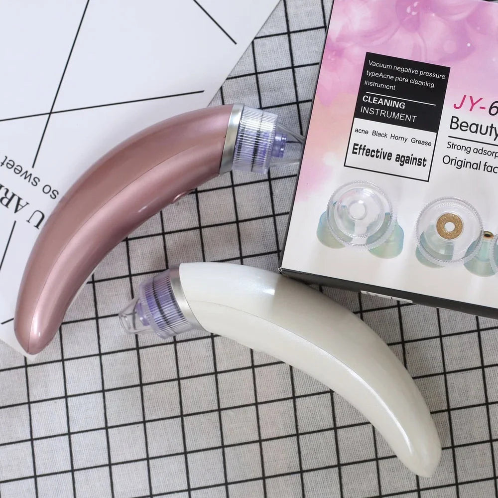 Electric blackhead suction instrument in rose gold and white colours for facial pore cleansing