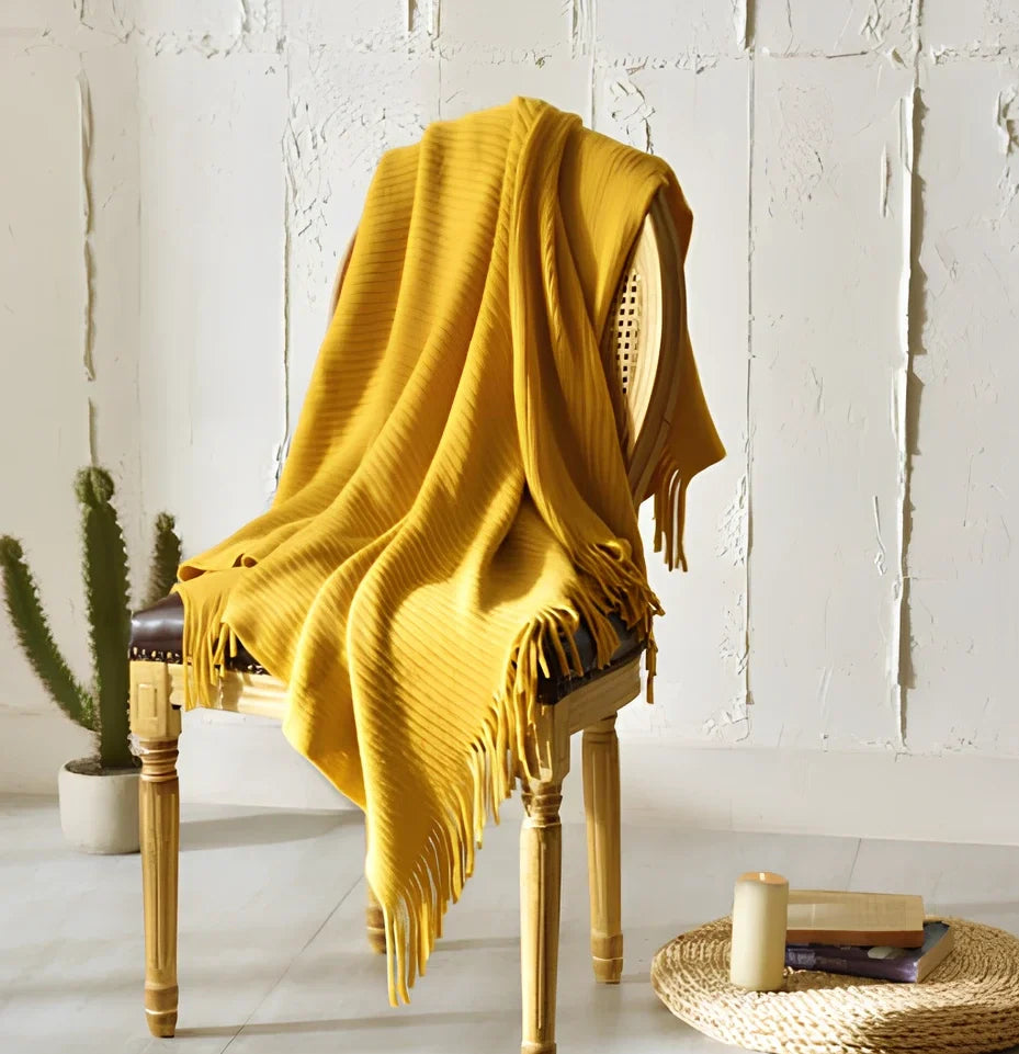 130x150cm knitted acrylic blanket with 10cm fringe detailing in beige colour draped over sofa