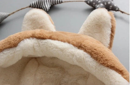 Baby wearing pink cotton coat with velvet accents, showing flocking fabric texture and cotton filling insulation