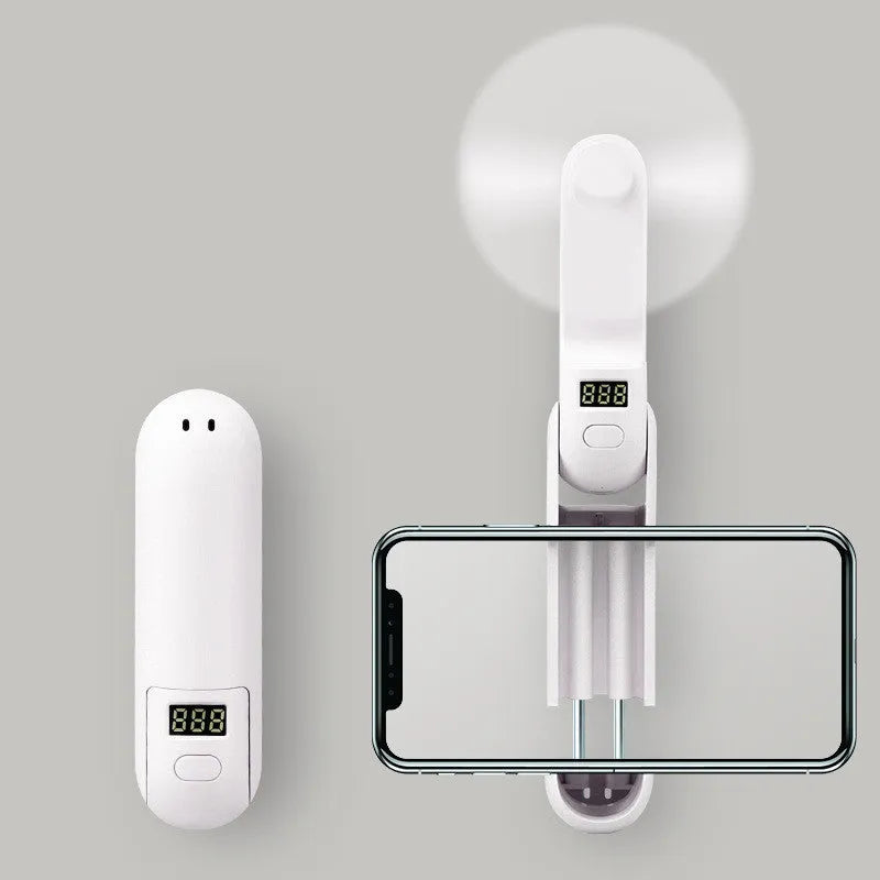 Green folding mini fan with plastic leaves in open position showing compact USB-rechargeable design