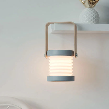 White foldable USB rechargeable LED night light in both table lamp and tall lantern modes.