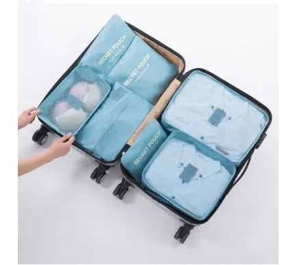 Set of six coloured nylon packing cubes and flat pouches for travel organisation.