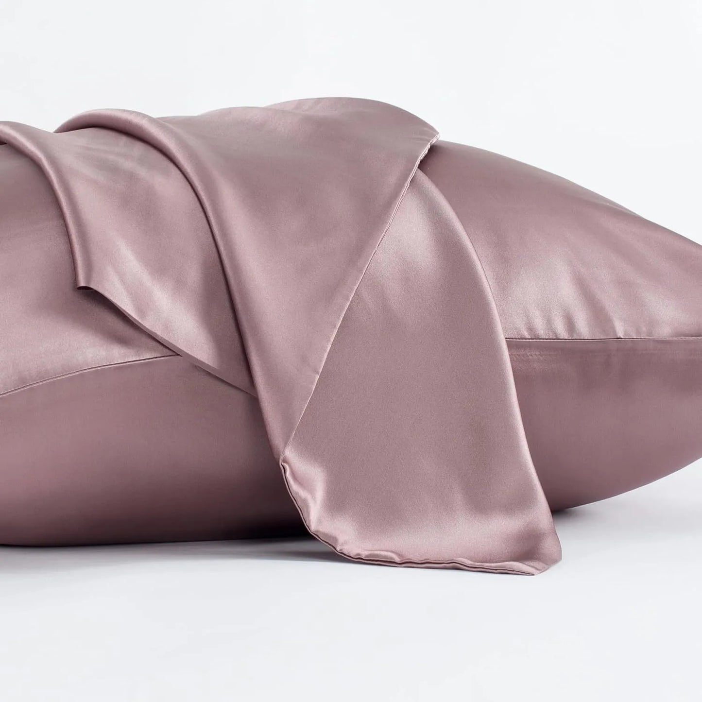 Dark grey silk pillowcase with envelope closure on a bed.
