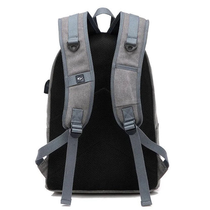 Coffee-coloured canvas backpack with USB charging port on side strap and front zipper pocket.