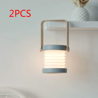 White foldable USB rechargeable LED night light in both table lamp and tall lantern modes.