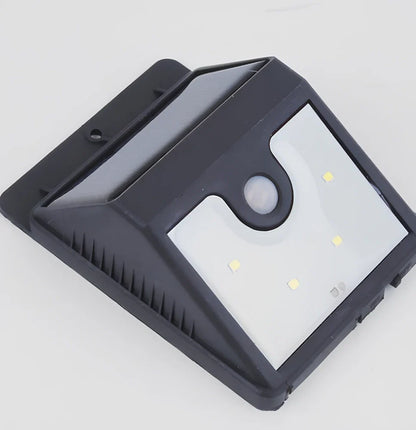 Solar 4 LED sensor lights mounted on garden wall, showing motion detection range and bright illumination at night
