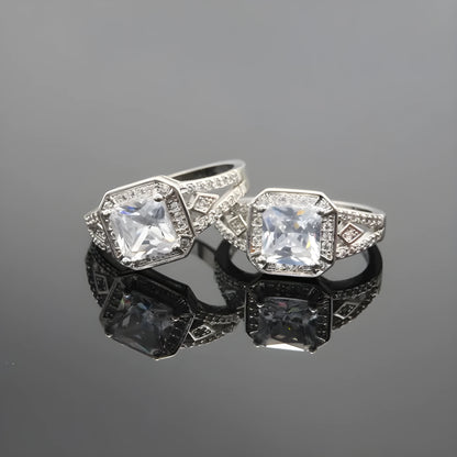 Geometric platinum-coloured copper ring with an inlaid zircon stone, showing its hollow quadrilateral design.
