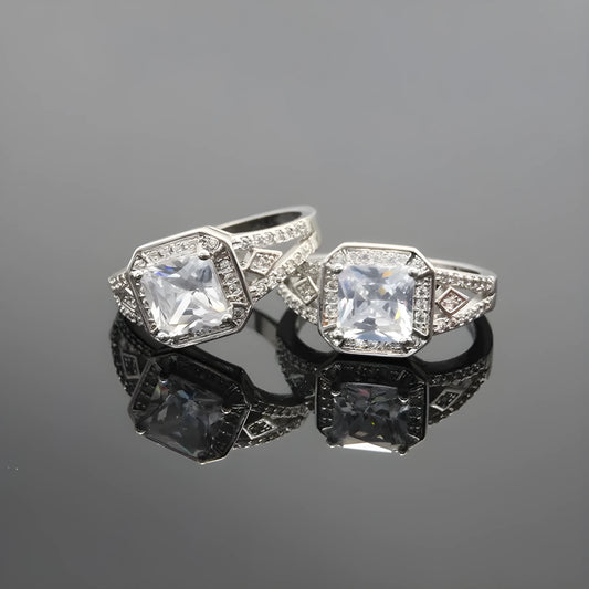 Geometric platinum-coloured copper ring with an inlaid zircon stone, showing its hollow quadrilateral design.