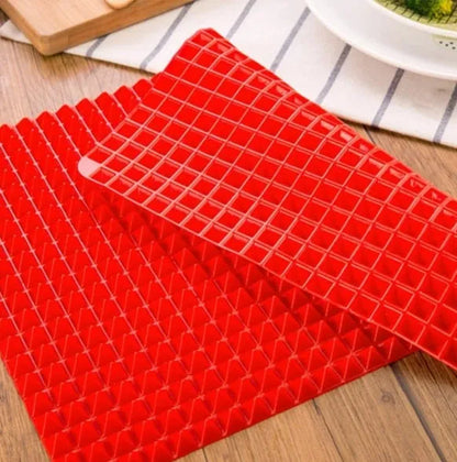 Red silicone pyramid grid cooking mat on a kitchen counter
