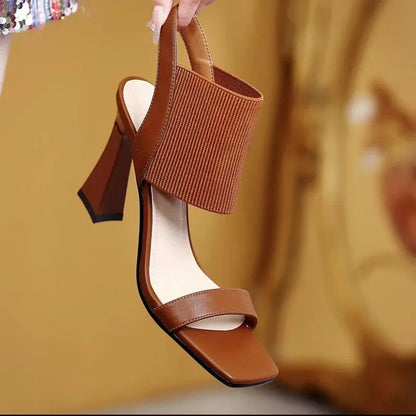 Black high heel sandals for women with criss-cross elastic straps and a rubber sole.