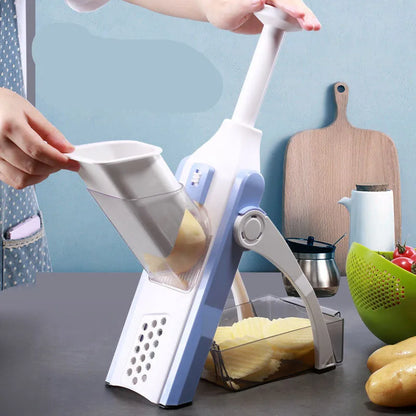 White and blue multifunctional vegetable slicer with stainless steel blades on a kitchen counter.