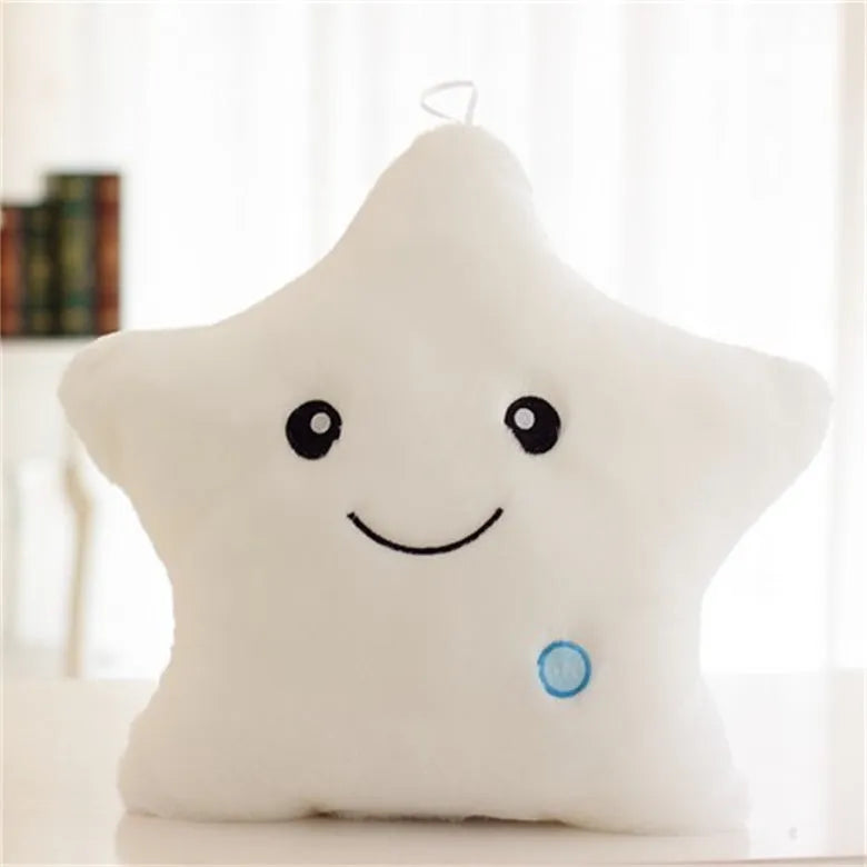 Colourful glowing five-pointed star plush pillow on a dark background.
