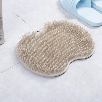 Orange non-slip massage bath brush with silicone bristles and suction cup base on shower floor