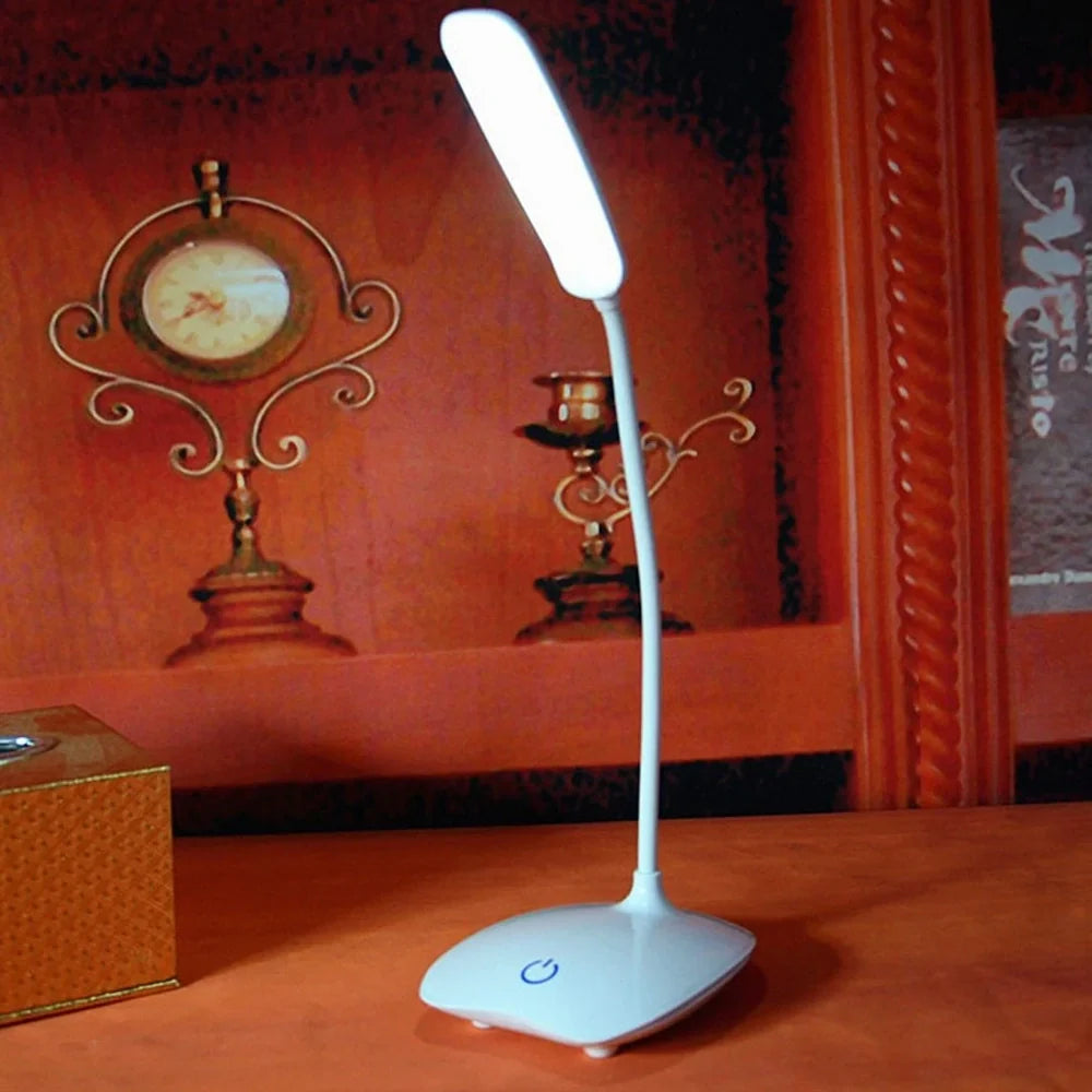 White foldable LED desk lamp with touch button and USB charging port on a desk