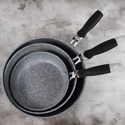Japanese-style Maifan stone frying pan with glass lid showing non-stick surface and compound bottom