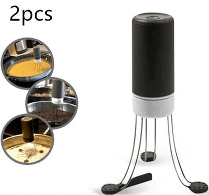 White and black wireless automatic kitchen stirrer with three-speed button, shown next to a saucepan.